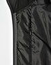 A black quilted jacket featuring a heather sleeve and a zippered pocket on the interior.