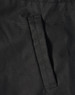 A close-up of a black fabric featuring a stitched pocket on a jacket. The material appears durable and textured.