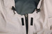 A close-up of a light grey waterproof performance jacket, featuring adjustable toggles and zip fastening.