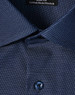 A navy blue men's button-up shirt featuring a pin dot pattern and a logo on the collar.
