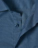 A close-up of a navy blue men's button-up shirt featuring a pin dot pattern and blue buttons.