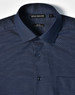 A navy blue button-up shirt featuring a pin dot pattern, with a single chest pocket and a branded label.