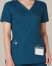 A solid colour teal scrub top with a V-neck, short sleeves, and pockets, featuring a logo on the pocket.