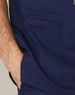 Men's scrub top in navy blue with contrast stitching and two front pockets. Features a logo on the fabric.