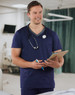 A men's short-sleeve scrub top in navy blue with a contrast colour neckline and a pocket, featuring a stethoscope.