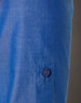 A close-up of a blue women's shirt featuring a button and a rolled-up sleeve. The fabric has a subtle texture.