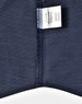 A close-up of a navy pin dot fabric showing a care label. The fabric has a textured, patterned design.