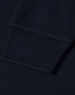 A close-up view of the cuff of a navy blue polo shirt featuring a ribbed design and a logo.
