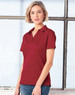 A woman wearing a burgundy short sleeve polo shirt with a collar. The shirt features a logo.