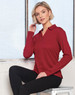 A long sleeve polo shirt in deep red, featuring a collar and a subtle logo. The model poses against a window.