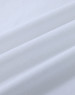 A close-up of white cotton fabric with soft, smooth texture, featuring natural wrinkles and folds.
