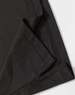 A close-up of a black polo shirt featuring a neatly stitched hem and collar. The fabric texture is visible.