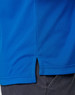A close-up of a blue polo shirt with a side vent detail, featuring a logo at the chest area.