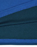 A close-up of a blue and dark green polo shirt featuring a textured fabric and a logo.