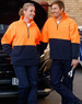 Hi-Vis polar fleece half zip pullover in bright orange and navy, featuring a logo, worn by two people by a vehicle.