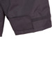 A close-up of a black safety jacket featuring a Velcro patch and reflective 3M tape accents.