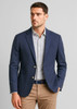 A navy blazer worn over a checked shirt, styled with beige trousers, featuring two buttons and a pocket.