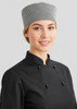 A woman wearing a black chef jacket with black buttons and a checkered chef hat.