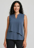A sleeveless layered blouse in a soft blue hue, featuring a v-neckline and loose fit. The model is smiling, showcasing the top.