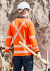A long sleeve polo shirt in hi-vis orange with reflective stripes, worn by a worker on a construction site.
