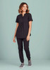 A black women's tunic scrub top is worn with matching pants, featuring a relaxed fit and button detail.