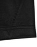 A close-up of a black polo shirt with a contrast sleeve hem and stitching detail. Features a logo on the side.