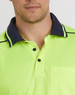 A close-up of a bright yellow unisex polo shirt with navy collar detailing and a pocket. It includes a logo.