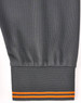 A grey long-sleeve polo shirt featuring segmented detailing with an orange stripe at the cuff. It has a logo on the garment.