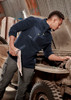 A man in a navy lightweight 1/4 zip polar fleece, working on a vehicle, with a logo on the garment.