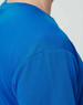A close-up of a men's short-sleeve t-shirt in a vibrant blue colour with a textured fabric. Features a logo.
