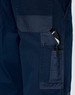 A close-up of navy blue work pants featuring multiple pockets, including a pen pocket, with visible stitching details.