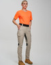 A pair of beige rip-stop poly/cotton stretch work pants displayed on a model wearing an orange shirt and sturdy boots.