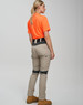 Work pants in beige with navy accents, paired with an orange shirt, displayed from the back. Features a logo.