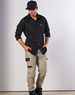 A model wearing a black long-sleeve work shirt and beige cargo pants, featuring two chest pockets and a logo.