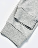 A pair of grey poly/cotton terry sweat pants with ribbed cuffs. The image highlights the fabric texture.