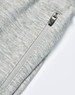A close-up of grey kids' poly/cotton terry sweat pants featuring a zip pocket and soft fabric texture.