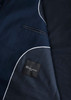 A navy blue men's jacket with white piping and a pocket design, featuring a branded label inside.