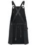 A black canvas apron with brass eyelets and PU straps featuring a front pocket and tie waist.