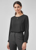 A black long sleeve blouse with a round neckline and a slight keyhole detail, paired with tailored trousers.