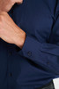 A navy blue men's long sleeve button-up shirt featuring a chest pocket and buttoned cuffs.