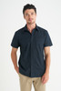 A navy short sleeve button-up shirt for men, featuring a collar and fitted style. The model stands casually with hands in pockets.