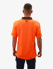 An orange work polo shirt with black detailing and a branding logo on the back.