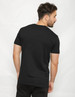 A black two-toned t-shirt featuring a simple design, with a view of the back on a model.