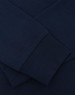 A navy blue long sleeve tee shirt featuring close-up details of the fabric and cuffs, with a logo present.