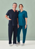 A navy blue and teal women's V-neck scrub top paired with matching pants, presented on a male and female model.