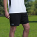 Dri Gear shorts in black, showcased alongside a white sports top, set against a green outdoor background.
