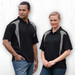 A black polo shirt featuring grey spliced panels, displayed on a male and female model. Includes a branding logo.