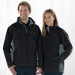A black and grey rain jacket with a logo, modeled by a man and a woman against a light wooden background.