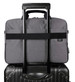 A grey laptop bag with a handle and strap, placed on top of a black suitcase. The bag has a logo.