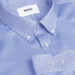 A light blue button-up shirt featuring a collared neck and subtle textured fabric, with a logo tag inside.